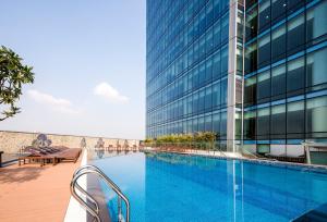 a swimming pool in front of a tall building at Lotte The Residence in Hanoi