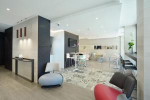 a living room with a table and chairs in it at Hotel des Alpes in Geneva