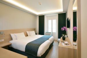 a hotel room with a large bed and flowers at Hotel des Alpes in Geneva