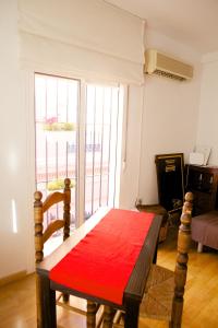 セビリアにあるCentro Magnífico Apartamentoのリビングルーム(赤い布のテーブル付)