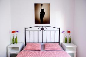 セビリアにあるCentro Magnífico Apartamentoのベッドルーム1室(ピンクのシーツと花瓶が入った黒いベッド1台付)