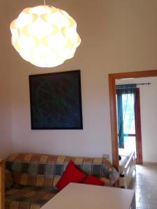 a living room with a couch and a chandelier at Residenze Sa Murta Marina in Monte Nai