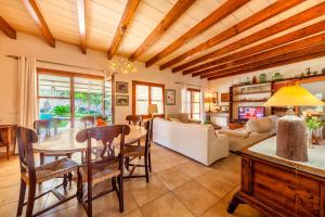 comedor y sala de estar con mesa y sillas en Pontarro, en Pollensa