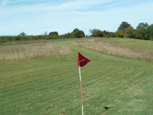 eine rote Flagge mitten auf einem Golfplatz in der Unterkunft Gîte Picanas in Boussan