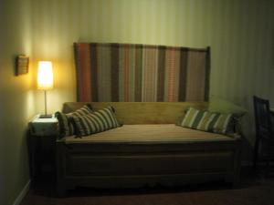 a bed in a room with a lamp next to it at Örnsköldsviks Vandrarhem in Örnsköldsvik