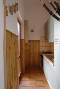 a kitchen with wooden cabinets and a stove top oven at Residenze Sa Murta Marina in Monte Nai