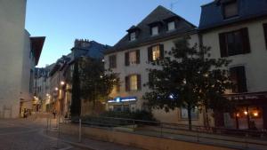 un groupe de bâtiments dans une rue la nuit dans l'établissement Le Bullière 60m2 plein centre!, à Rodez