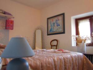 una camera con letto e tavolo con lampada di Residenza Torre Antica a Sommacampagna