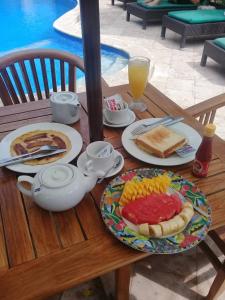 a table with plates of breakfast food on it at Rumah Saga in Gili Trawangan