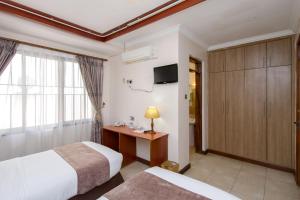 a hotel room with two beds and a television at Victoria Comfort Inn in Kisumu +31 photos