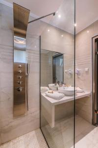 Filerimos Village Hotel في إياليسوس: حمام مع حوض ومرآة