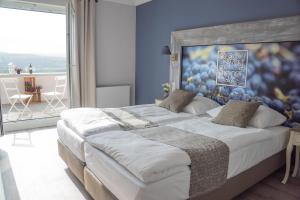 a bedroom with a large bed with a blue wall at Winzerhotel Trautwein in Flonheim