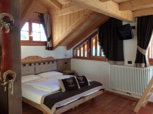 um quarto com uma cama num quarto com tectos em madeira em B&B Mas di Zonadi em Rabbi