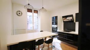 a kitchen with a table and a clock on the wall at T4 du Languedoc in Toulouse