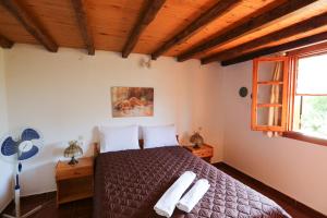 a bedroom with a bed with two towels on it at Villa Marigo in Kolios