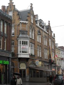 een gebouw op een straat waar mensen voor lopen bij All-In Hotel in Den Bosch