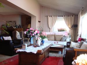 un soggiorno con un divano e un tavolo con fiori di Chambres d'hôtes Aux Portes de Bréhat a Ploubazlanec