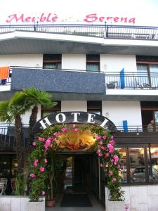 un hôtel avec un panneau de fleurs à l'avant dans l'établissement Hotel Serena, à Grado