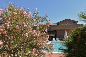 une villa avec une piscine et des fleurs roses dans l'établissement Residence San Rossore, à Pise