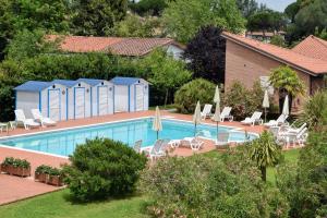 a pool with chairs and umbrellas next to a house at Residence San Rossore in Pisa