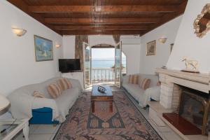 a living room with a couch and a fireplace at Sweet Memories Beach Houses in Mesongi