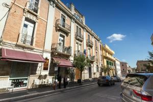 una calle de la ciudad con coches aparcados en la calle en Matera In Vacanza en Matera