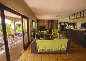 ein Wohnzimmer mit einem Sofa und einem Tisch in der Unterkunft Southern Light Country House in Kapstadt