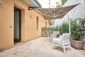 a patio with two chairs and an umbrella at Domus Il Palio in Siena