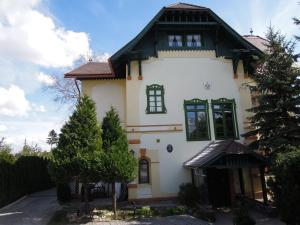 a white house with a black roof and green windows at Zámok u Grofa in Nitra