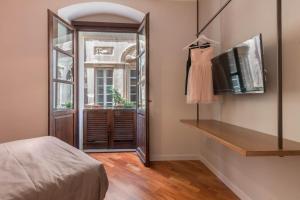 a room with a bed and a television and a window at Suite Cagliari -101- in Cagliari