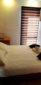 a bedroom with a large white bed with a window at City Suites in Eilat