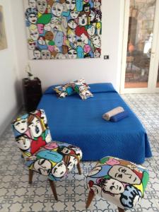 a bedroom with a bed and two chairs with hello kitty patterns at Domus Felix in Sorrento