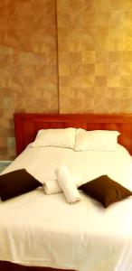 Una cama con sábanas blancas y almohadas. en City Suites, en Eilat
