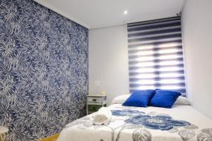 1 dormitorio con 2 camas y pared azul en Mequedo San Pascual, en Alcañiz