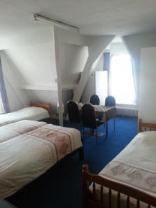 Habitación con 3 camas, sillas y ventana en All-In Hotel en Den Bosch