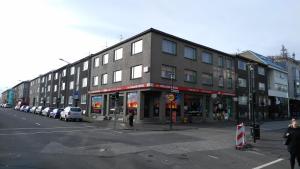 un gran edificio en una calle de la ciudad con coches aparcados en 100 Iceland Hotel en Reikiavik