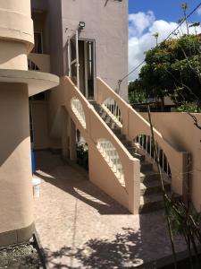 a staircase leading up to a house with a door at BR Apartment & Studios in Curepipe
