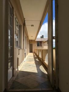 an empty hallway of a building with the sun shining through the windows at BR Apartment & Studios in Curepipe