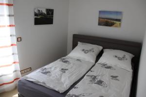 a bed with two pillows on it in a bedroom at Villa Gutenberg in Binz