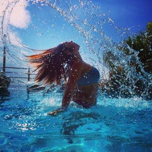 Eine Frau spielt in einem Pool voller Wasser in der Unterkunft Studio Alba Beach in El Campello