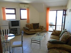 a living room with a couch and a table at Nedev's Apartments in Lazur 2 Complex in Sozopol