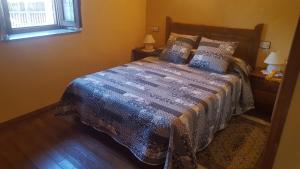1 dormitorio con 1 cama con edredón azul en El Cotorollu, en Onís