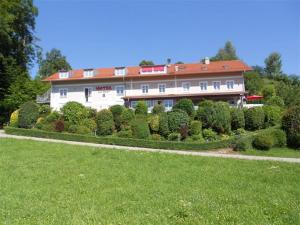 a large house with a lot of bushes and trees at Hotel Auf Wolke 8 in Trostberg an der Alz