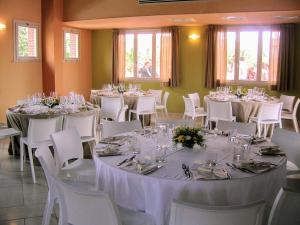uma sala cheia de mesas e cadeiras com mesas brancas e cadeiras brancas em Residence San Rossore em Pisa