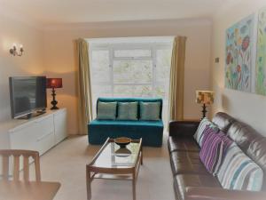 a living room with a couch and a tv at 2 Bedroom Apartment in Stratton Court Central Surbiton incl Free Parking in Kingston upon Thames