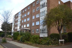 a large brick building on the side of a street at 2 Bedroom Apartment in Stratton Court Central Surbiton incl Free Parking in Kingston upon Thames