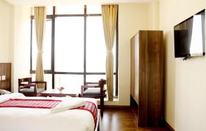 カトマンズにあるHotel Kathmandu Innのベッド2台とテレビがあるホテルの部屋