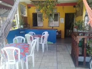 ein Esszimmer mit weißen Stühlen und einem Tisch in der Unterkunft Nega Maluca Guesthouse in Salvador