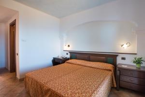 a bedroom with a bed with a orange bedspread at Hotel Lido degli Spagnoli Wellness & Spa in Portoscuso