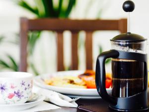 una caffettiera seduta su un tavolo con un piatto di cibo di Carlton House Scarborough a Scarborough